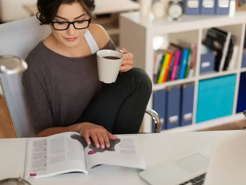 Espaço de estudo organizado com mesa, computador e materiais escolares